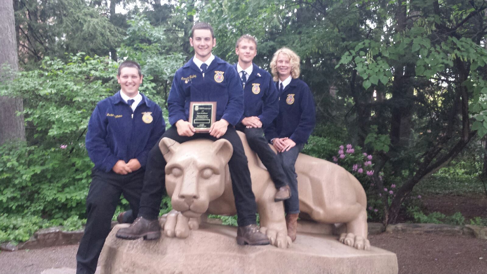 The Biglerville FFA agricultural mechanics team with their plaque on the Nittany Lion statue at Penn State, June 2016; Jake Grim at right