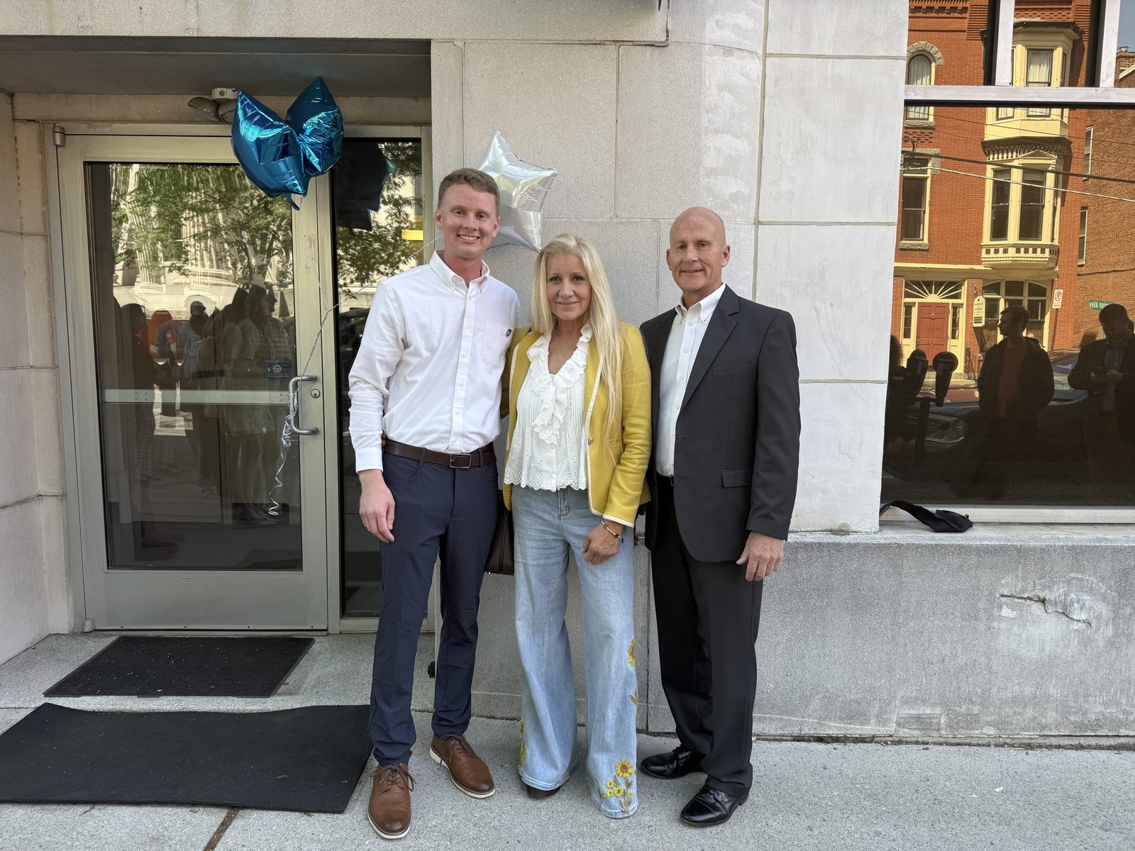 Jake Grim with his parents at the ribbon cutting for his office